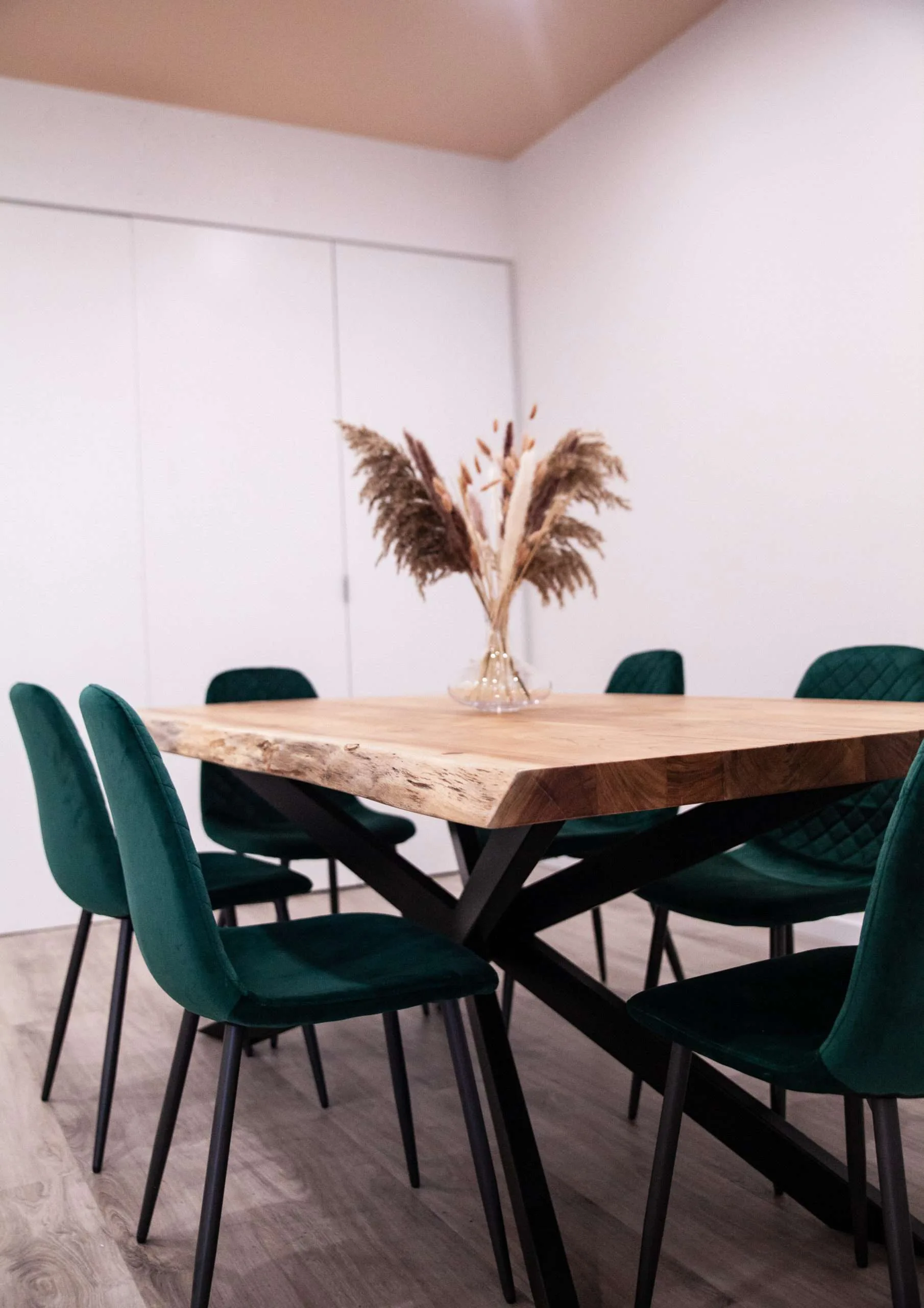 Artistry Academy training room with live-edge timber table and green chairs