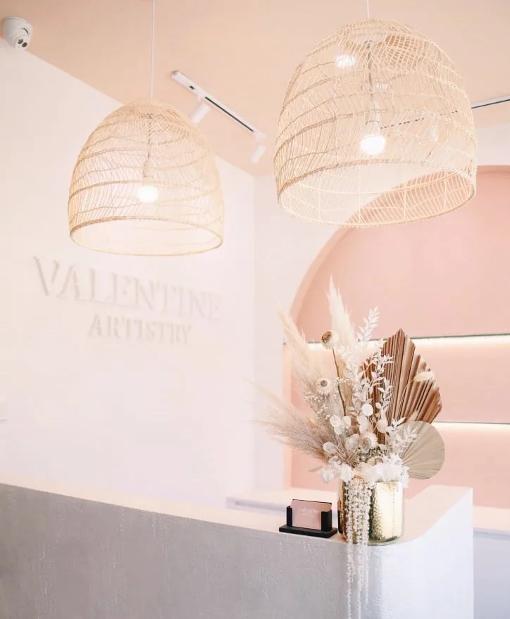 Valentine Artistry reception with embossed wordmark, rattan lamps and pink arch